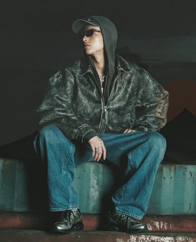 Seated model in a washed leather jacket and wide-leg denim
