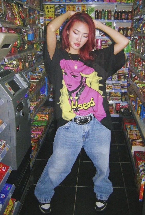 Model wearing a graphic tee in a colorful convenience store